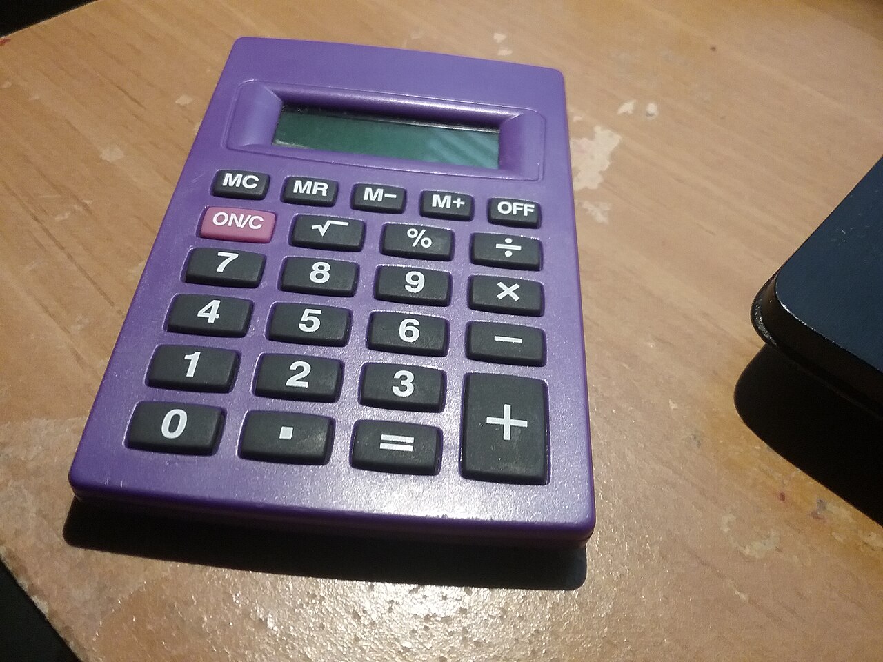 A basic four-function pocket calculator on a flat surface